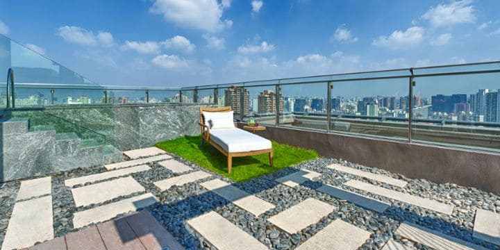 A rooftop with a Jacuzzi and a patch of lawn