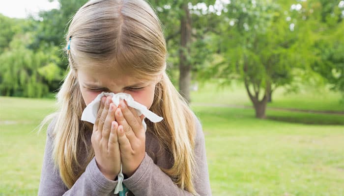 Girl blows her nose due to grass allergy
